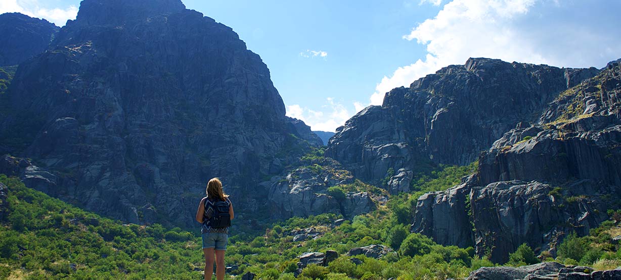 Girl with backpack looking at Serra da Estrela mountains