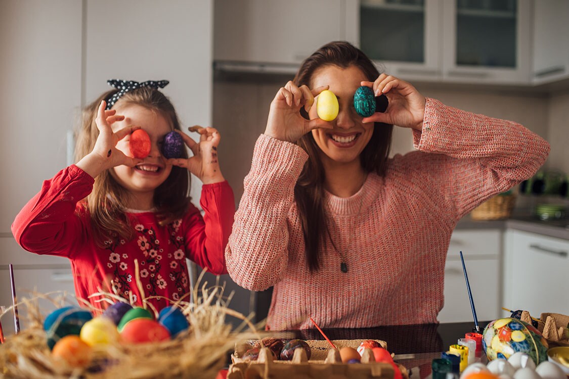 Mum and daughter with painted Easter eggs.