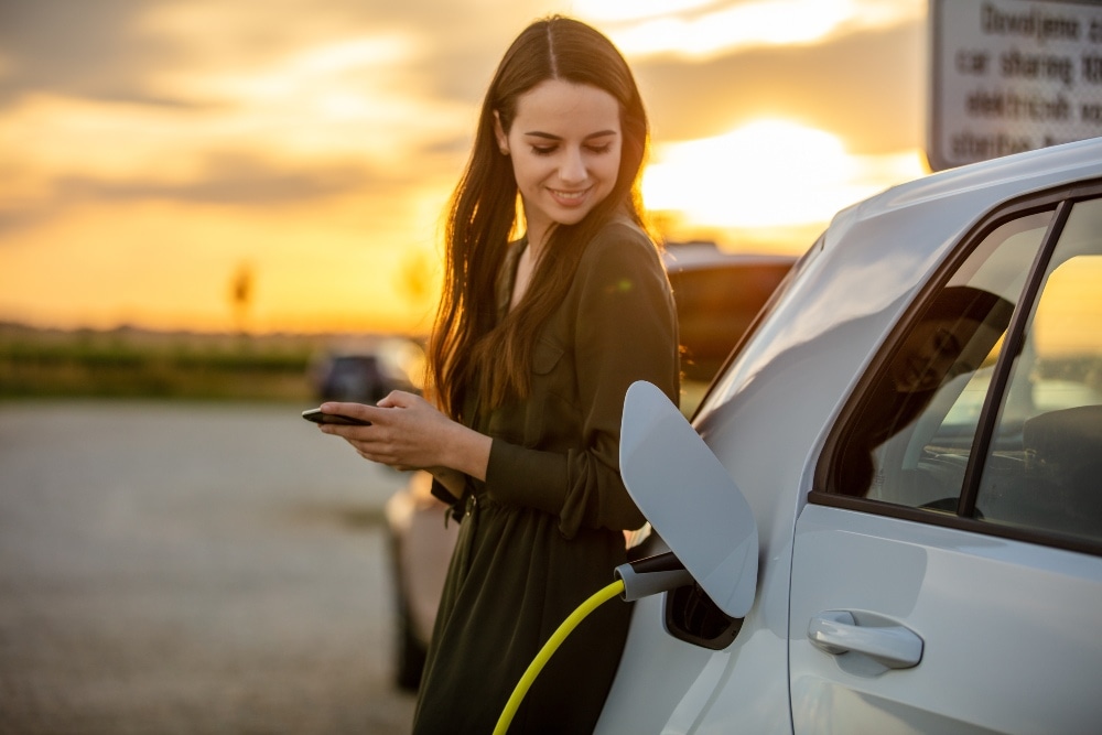 Mulher com carro elétrico