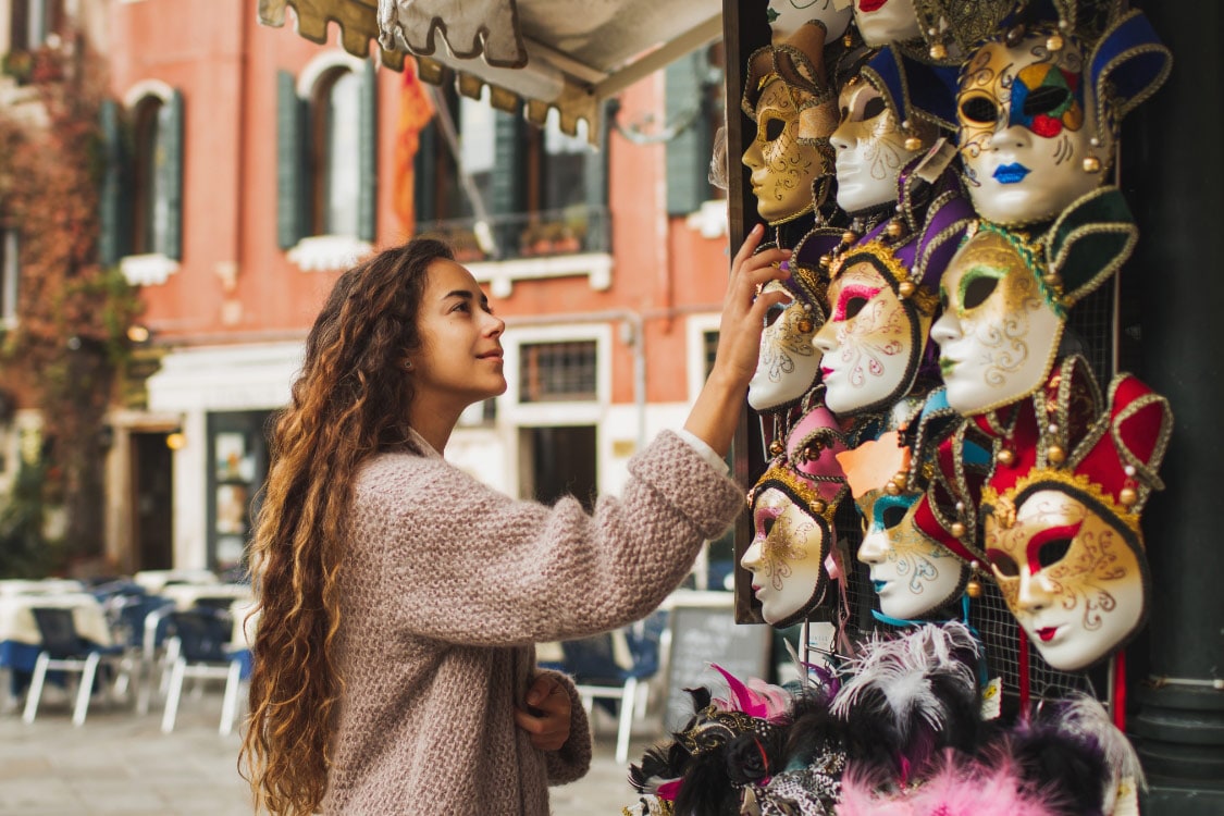 mulher a ver máscaras coloridas do carnaval de veneza.