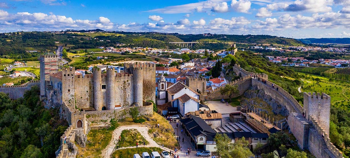 obidos o que visitar: Vista aérea da histórica cidade de Óbidos, pôr do sol, perto de Lisboa, Portugal.