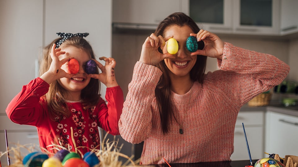 Mãe e filha com ovos pintados de Páscoa.